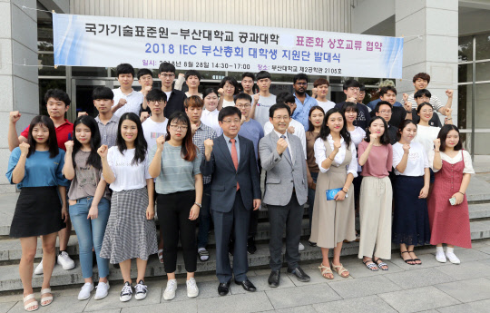 지난달 28일 부산대학교 국제회의실에서 열린 '2018 국제전기기술위원회(IEC) 부산총회' 대학생 지원단 발대식에 참가한 허남용 산업통상자원부 국가기술표준원장(맨 앞줄 왼쪽 다섯번째) 등이 행사 성공을 위한 결의를 다지고 있다.  연합뉴스